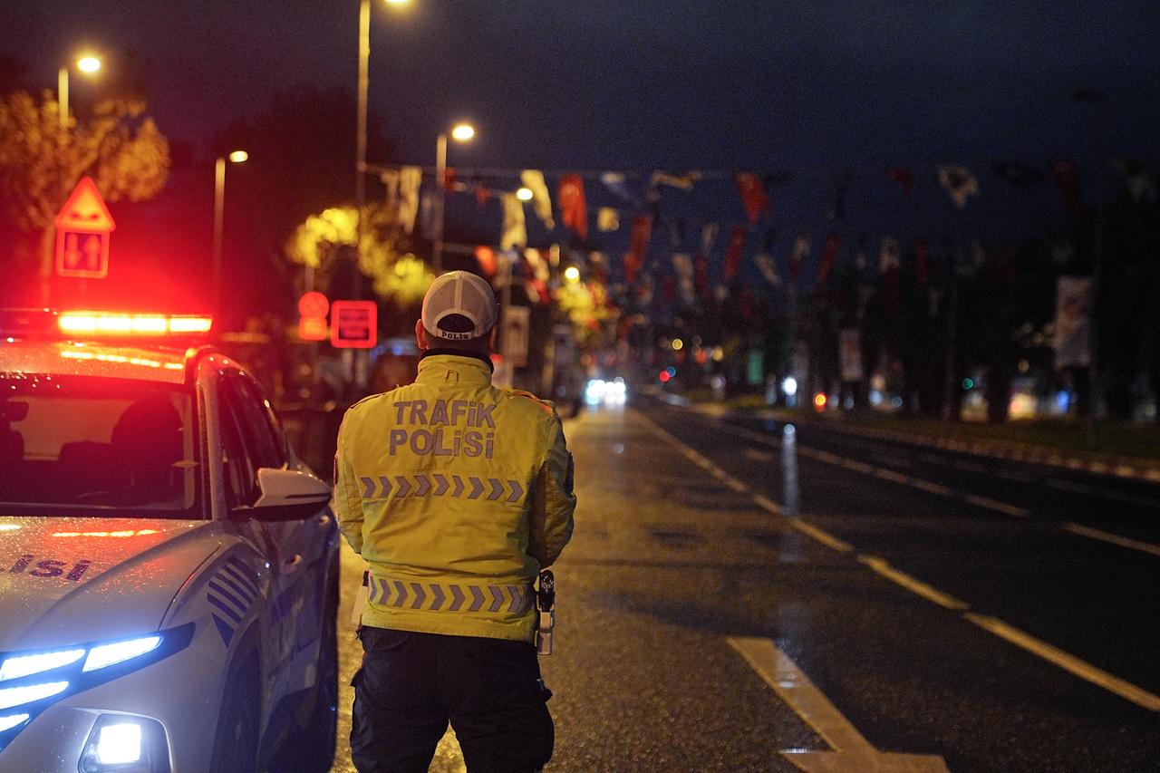 A traffic police officer stands beside a patrol car on Adnan Menderes Boulevard during early-morning road closures for the Republic Day parade rehearsal in Istanbul, Türkiye, October 19, 2025. (AA Photo)