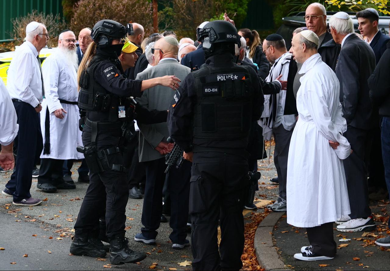 Armed police officers talk with members of the community near Heaton Park Hebrew Congregation synagogue in Crumpsall, north Manchester, Oct. 2, 2025. (AFP Photo)