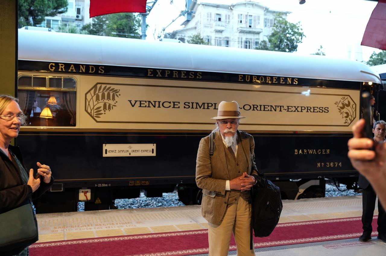 A traveler poses in front of the Venice Simplon Orient Express following its arrival at Bakirkoy station in Istanbul, Türkiye, Oct. 1, 2025. (IHA Photo)