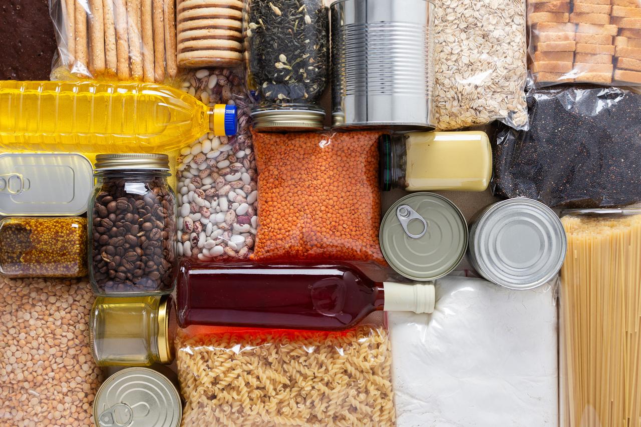 Home emergency food stockpile with canned goods, grains, pasta, and essential staples prepared for quarantine or isolation. (Adobe Stock Photo)