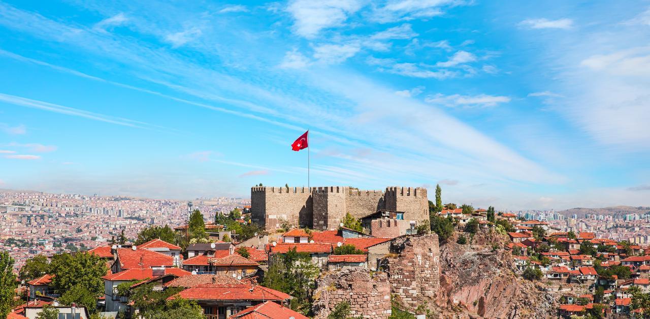 The historic Ankara Castle rises over the city’s old quarter beneath the Turkish flag. (Adobe Stock Photo)
