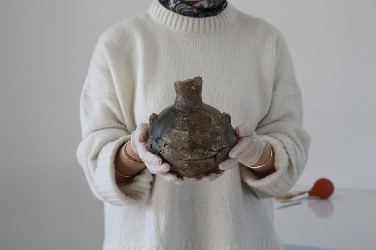 Denizli'nin Çal ilçesi Aşağıseyit Höyük'te ortaya çıkarılan 4.500 yıllık gemi, kazı ekibinin elinde, 21 Ekim 2025. (AA Fotoğraf)
