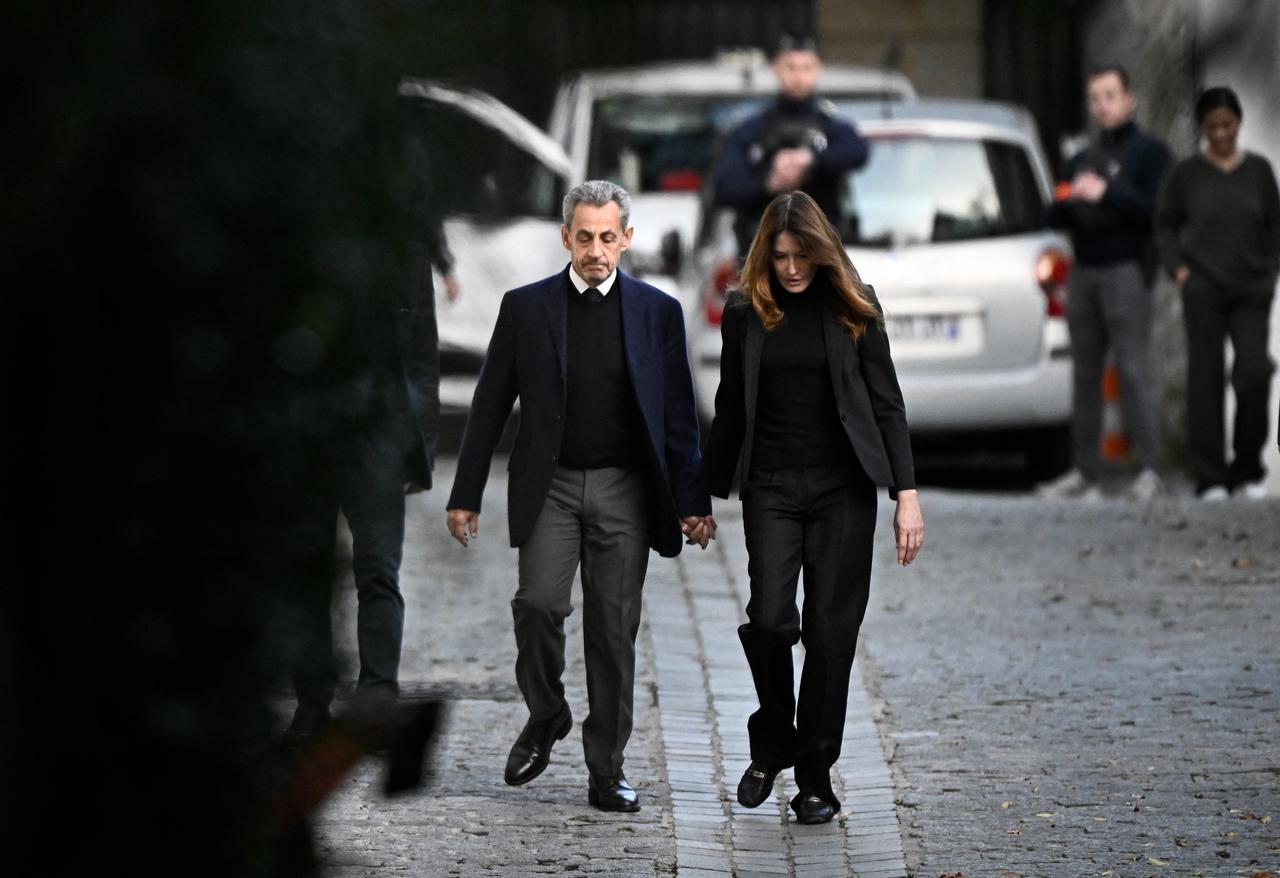 France's former president Nicolas Sarkozy (L), with his wife Carla Bruni-Sarkozy, leaves his residence to present himself to La Sante Prison for incarceration on a five-year prison sentence after being convicted of criminal conspiracy over a plan for late Libyan dictator Moamer Kadhafi to fund his 2007 electoral campaign, in Paris, on Oct. 21, 2025. (AFP Photo)