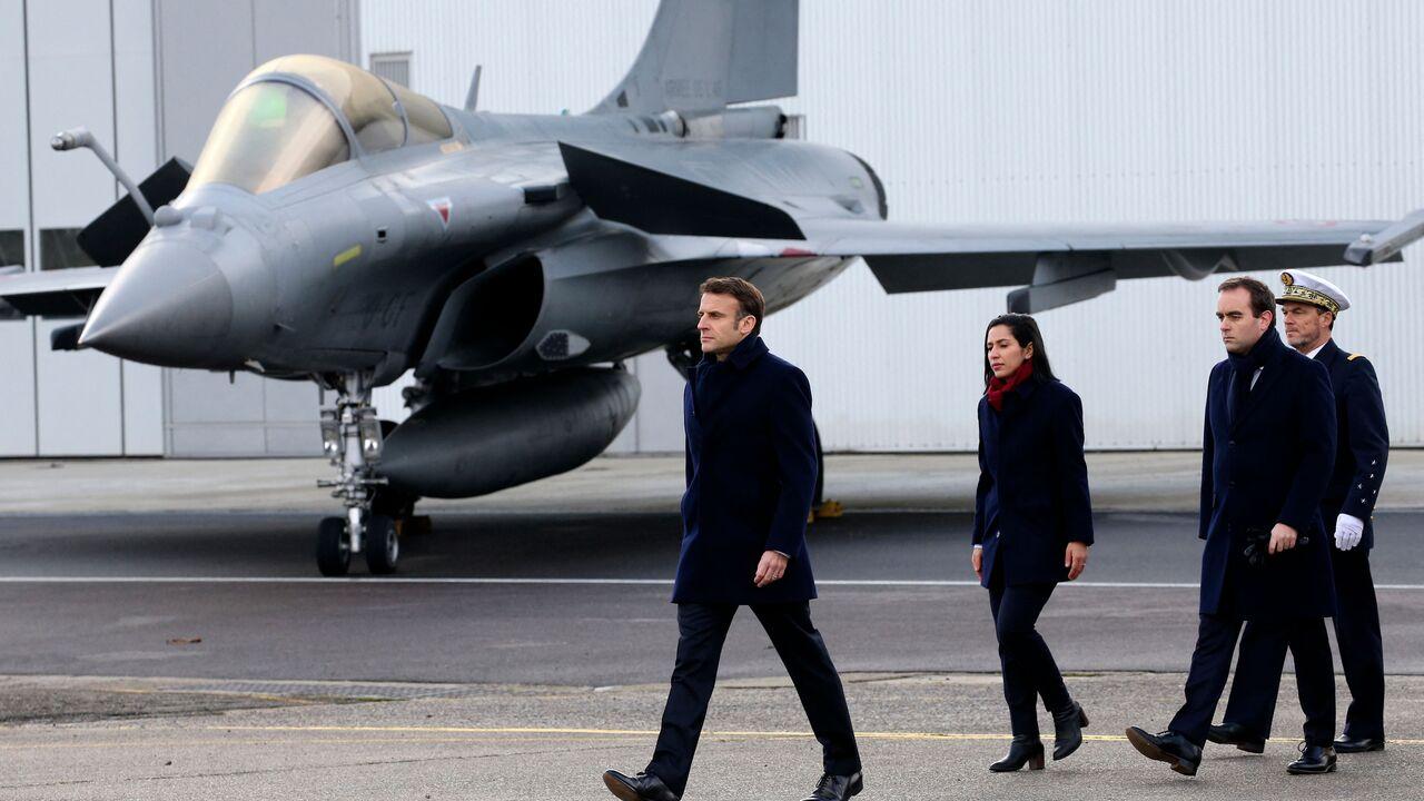 French President Emmanuel Macron, followed by French Armies Minister Sebastien Lecornu (2nd R), walks past a Dassault Rafale fighter aircraft, Jan. 20, 2023. (AFP Photo)