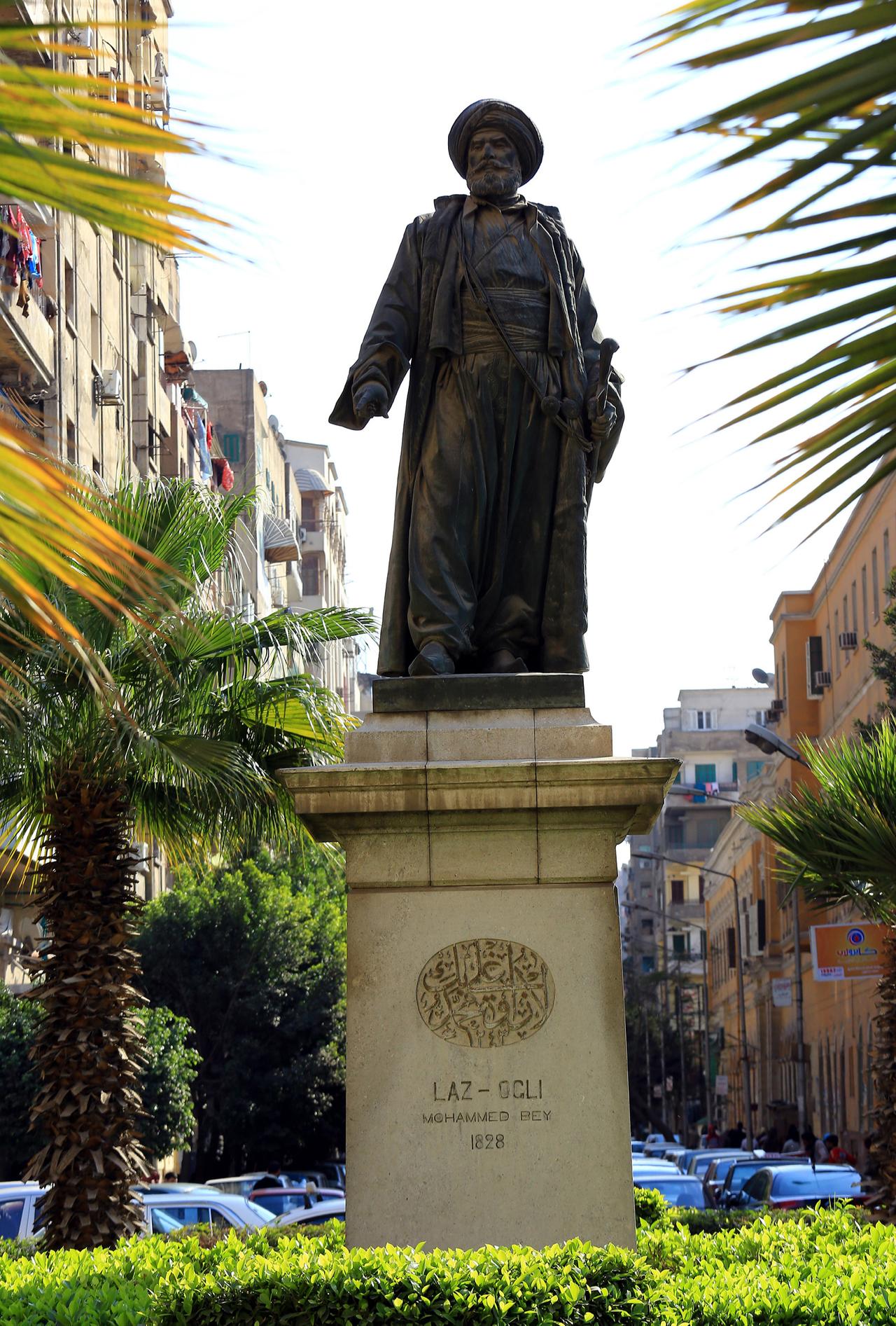 Pedestrians pass Lazoghly Square in downtown Cairo, where the 19th-century statue of Laz Oghli Pasha rises among palm trees and apartment blocks, Feb. 21, 2013. (AA Photo)
