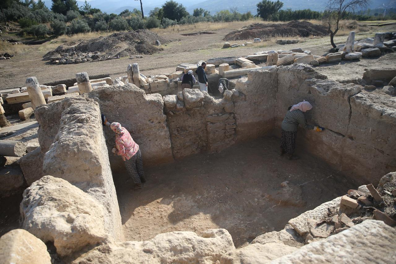 Workers clean soil layers inside a shop unit unearthed at the agora of Hyllarima ancient city, Kavaklidere, Mugla, Türkiye, Oct. 22, 2025. (AA Photo)