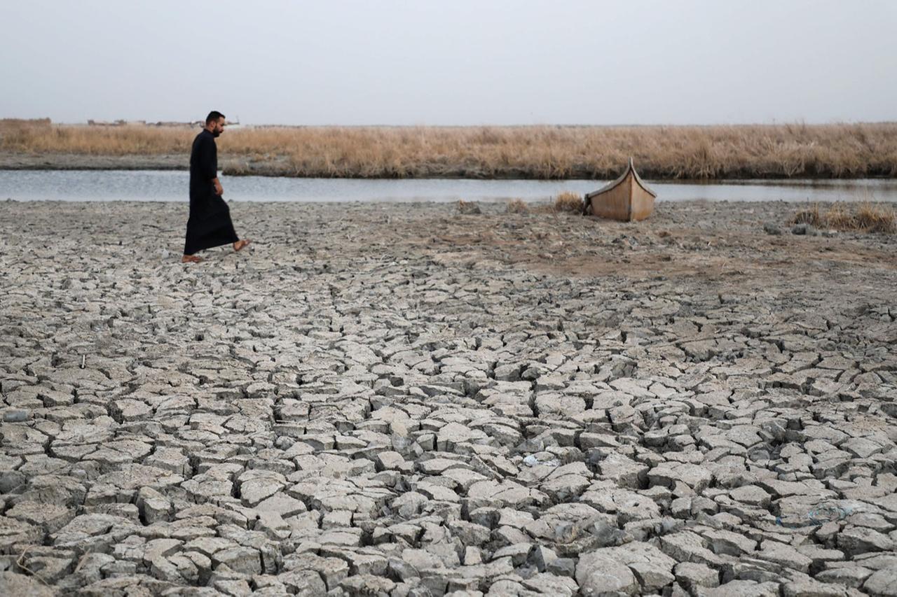 A demonstrator approaches a boat stuck in the dried-up bank of a canal, during a rally at the Umm El Wadaa marsh, south-east of the Iraqi city of Nasiriyah in southern Dhi Qar province, Aug. 16, 2022. (AFP Photo)