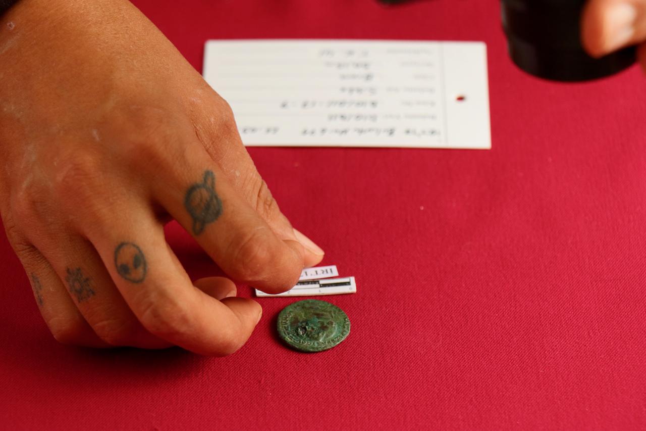 Bir arkeolog, Hisardere kazılarında bulunan bronz parayı inceliyor, İznik, Bursa, Türkiye, 22 Ekim 2025. (AA Fotoğraf)