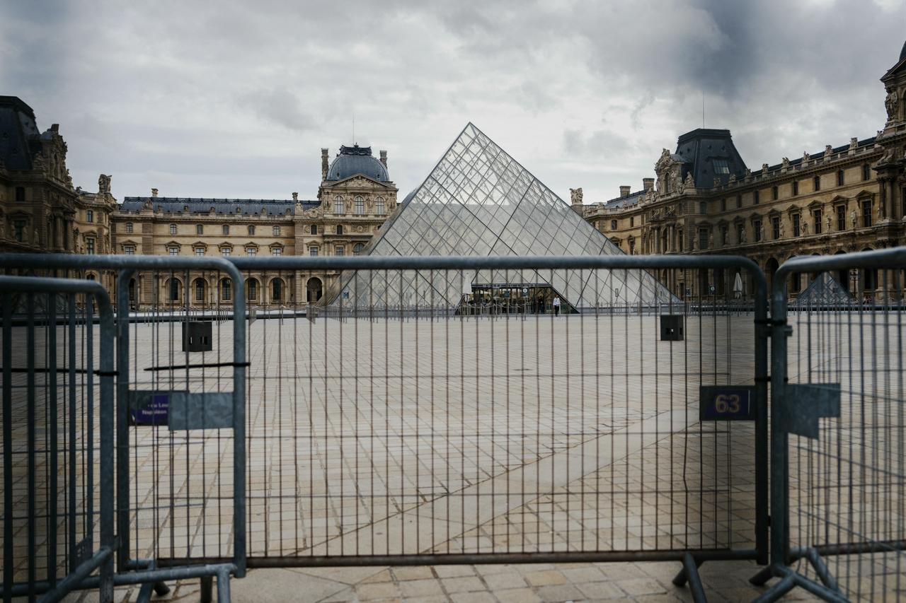The Louvre pyramid courtyard is seen completely empty behind barriers installed following the announcement that the museum will remain closed for a second day after thieves stole priceless jewels from the museum in Paris a day earlier, in Paris, France, Oct. 20, 2025. (AFP Photo)