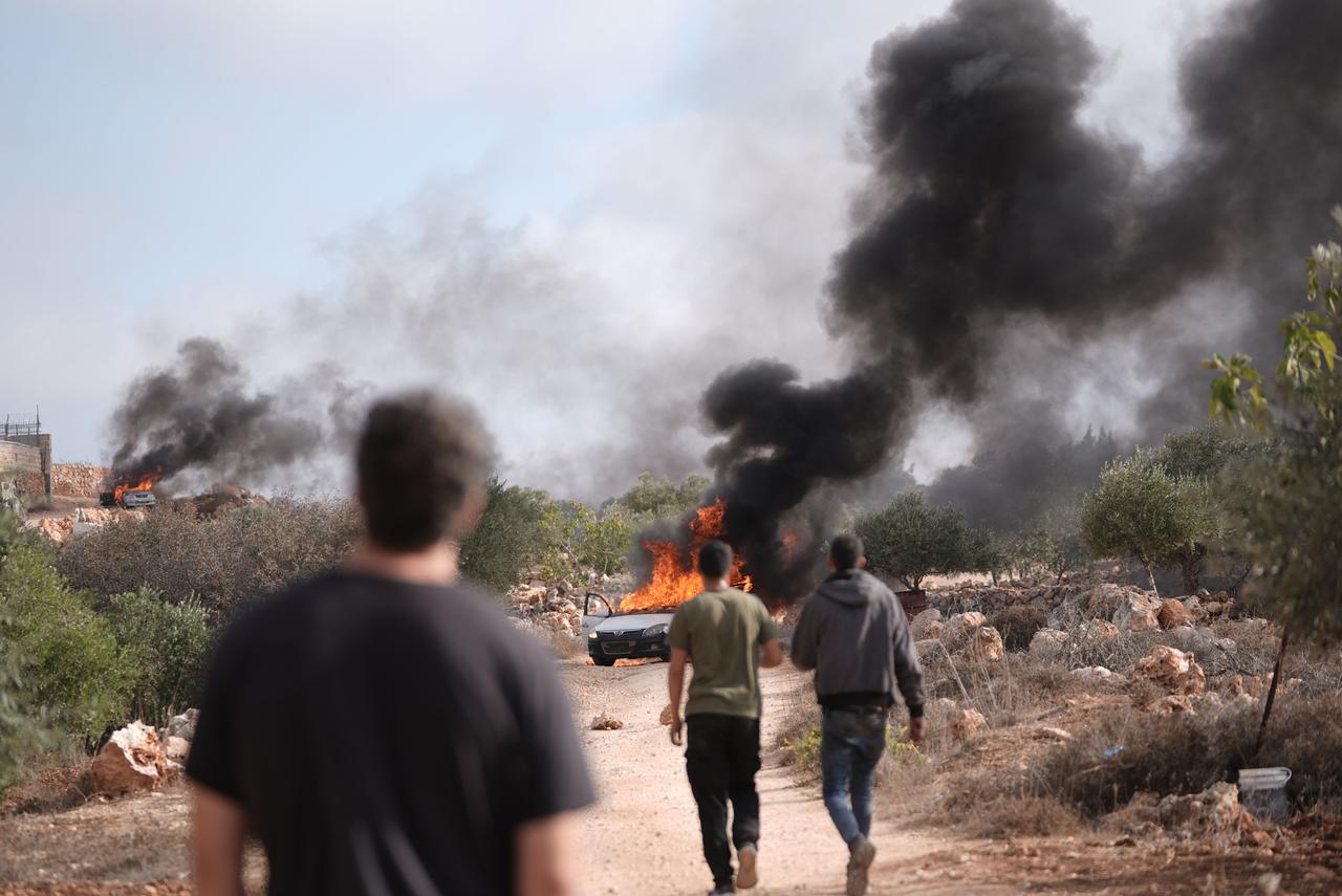 Smoke and flames rise from vehicles belonging to Palestinians, set on fire by Israelis seizing Palestinian land under the protection of Israeli soldiers, in Turmus Ayya near Ramallah, West Bank, Oct. 19, 2025. (AA Photo)