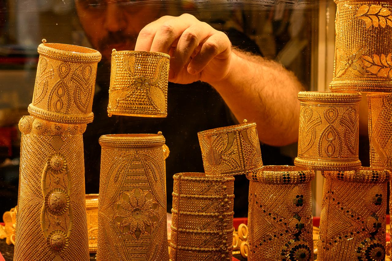 A salesperson displays gold bangles for sale in a gold shop at the Grand Baazar in Istanbul, Türkiye, on October 10, 2025. (AFP Photo)
