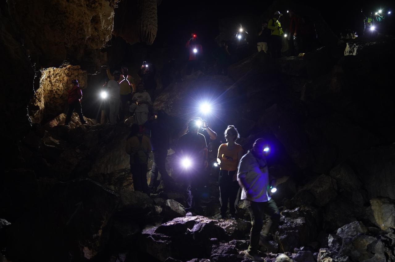 A group of visitors illuminate the dark interior of Kuneba Cave with flashlights during an exploration in Sulaymaniyah, Iraq, Oct. 24, 2025. (AA Photo)