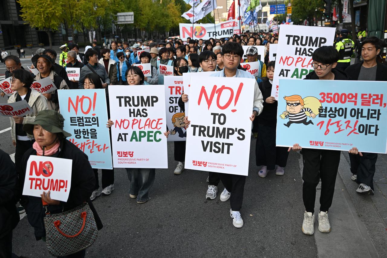 Protesters carry placards as they march during a rally, condemning U.S. President Donald Trump's pressure for increased South Korean investment in the US, in Seoul on October 25, 2025. (AFP Photo)