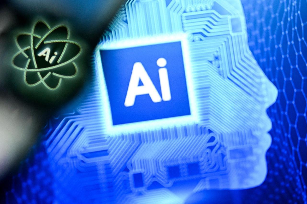 The letters AI for Artificial Intelligence on a laptop screen (R) next to the logo of the Chat AI application on a smartphone screen in Frankfurt am Main, western Germany on Jan. 2, 2025 (AFP Photo)