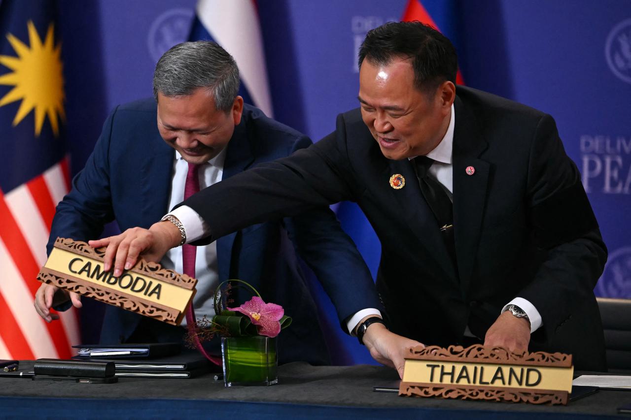 Cambodia's Prime Minister Hun Manet (L) smiles as Thailand's Prime Minister Anutin Charnvirakul swaps around the country name signs during a ceremonial signing of a ceasefire agreement on the sidelines of the 47th Association of Southeast Asian Nations (ASEAN) Summit in Kuala Lumpur on Oct. 26, 2025. (AFP Photo)