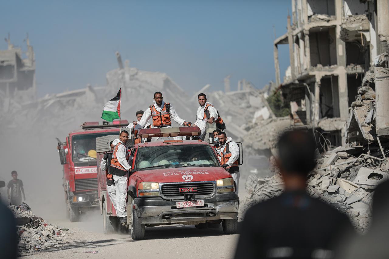Palestinian civil defense teams collect the remains from the destroyed cemetery and carry out reburial procedures in Beit Lahia, Gaza, Oct. 26, 2025. (AA Photo)