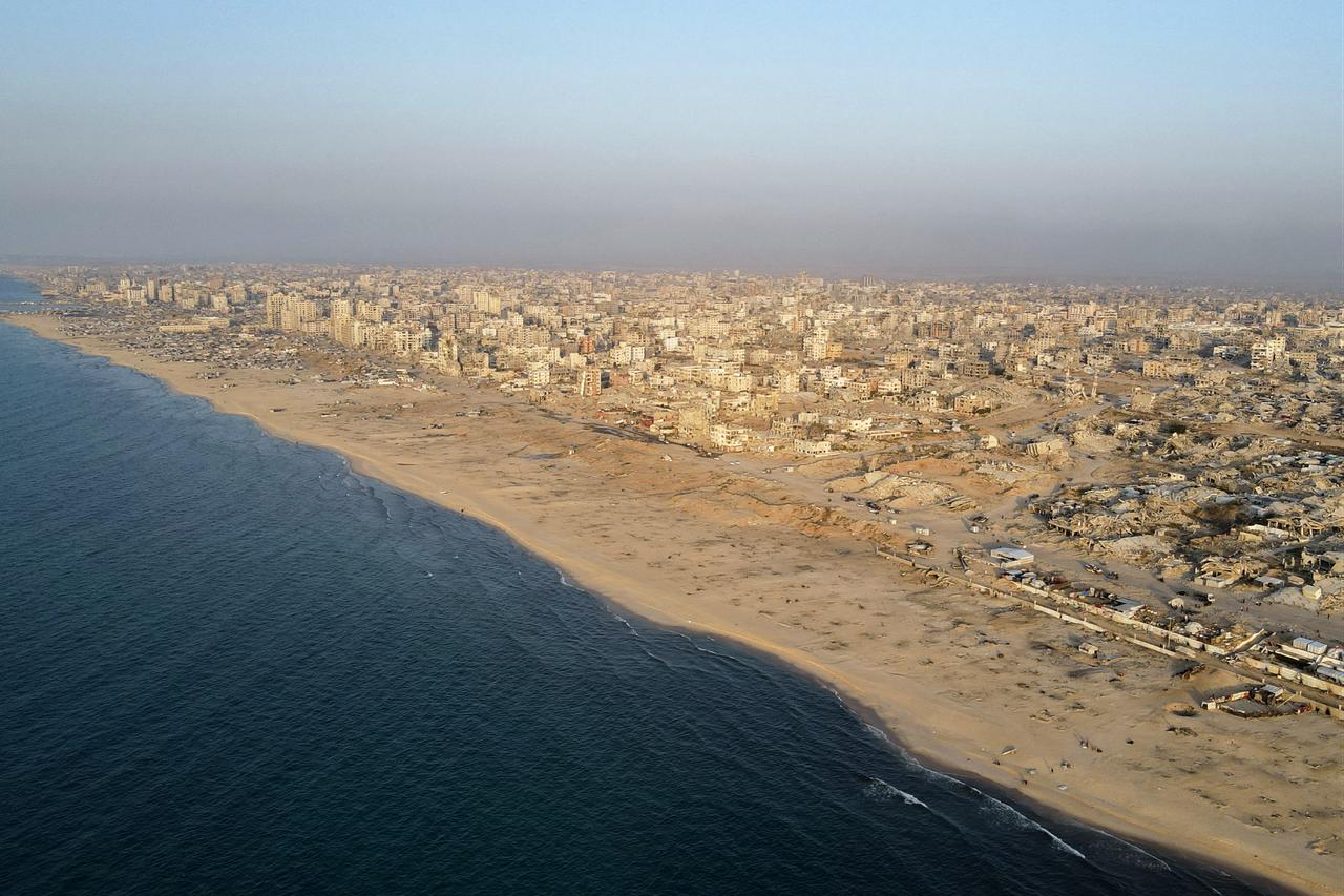This aerial picture shows the coastal Al-Rashid road next to destroyed buildings in Gaza City's Al-Remal neighbourhood on October 23, 2025. (AFP Photo)