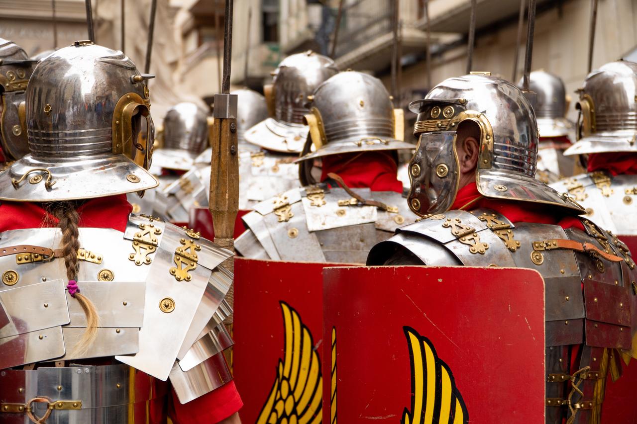 Roman legionaries in full armor with red shields bearing the thunderbolt insignia. (Adobe Stock Photo)
