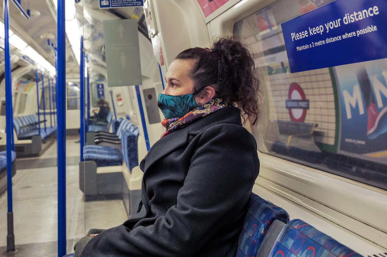 A woman wearing a face mask is on board a metro train during the COVID-19 lockdown in England. (Adobe Stock Photo)