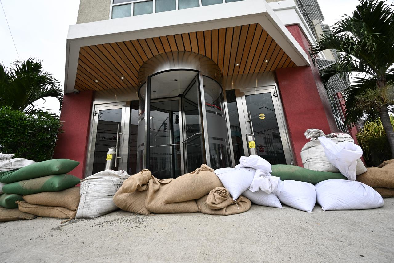Sandbags have been positioned at the entrance of the Grace Kennedy building in downtown Kingston, Jamaica, ahead of Hurricane Melissa, October 25, 2025. (AFP Photo)