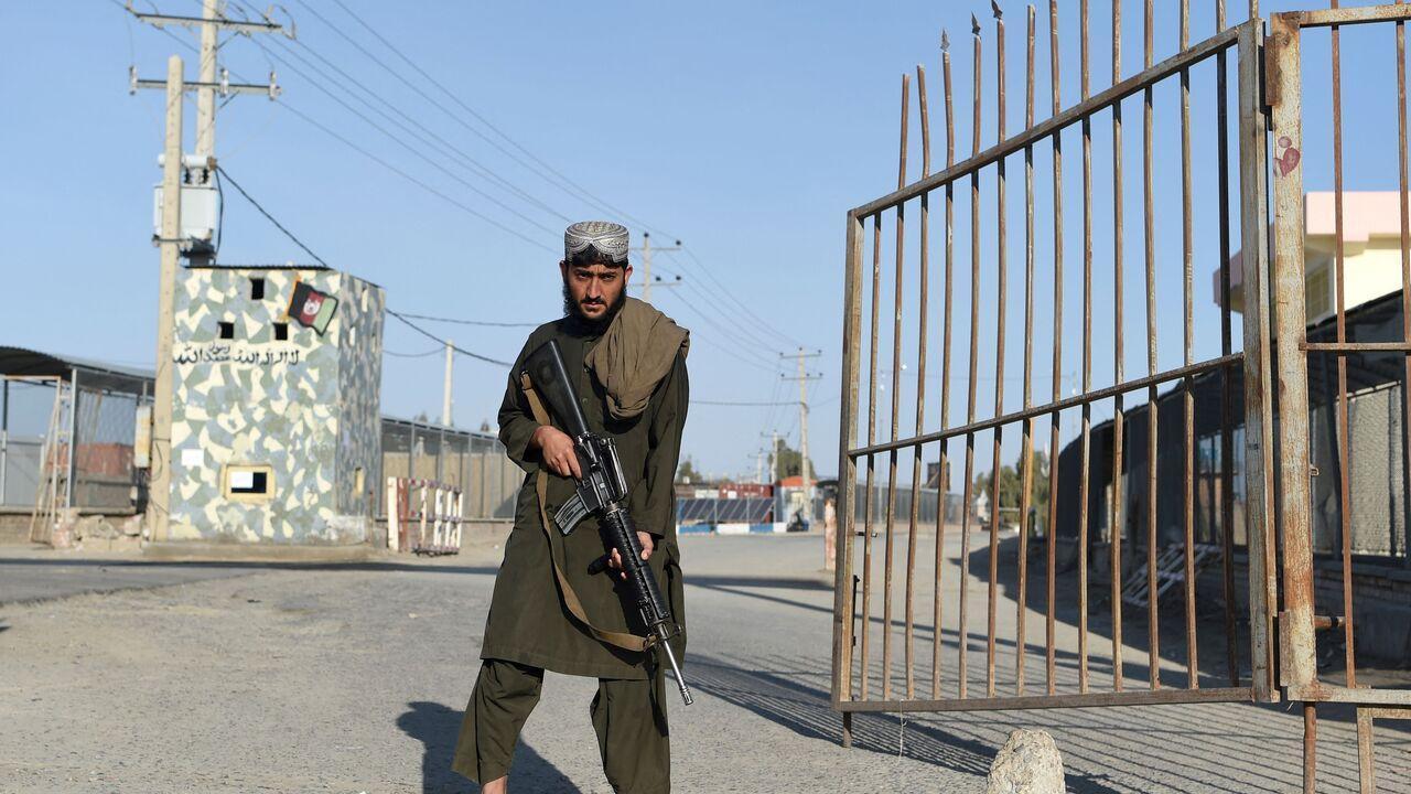A Taliban fighter stands guard at the entrance gate of Afghan-Iran border crossing bridge in Zaranj on Feb. 18, 2022. (AFP Photo)