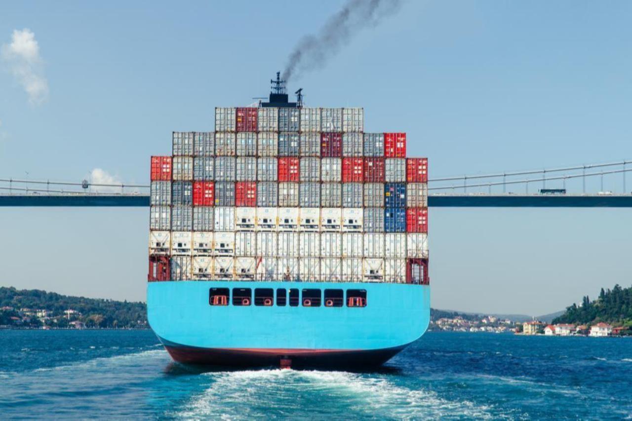 A view of a fully loaded container ship passing beneath the Fatih Sultan Mehmet Bridge on the Bosporus Strait in Istanbul, Türkiye. (Adobe Stock Photo)
