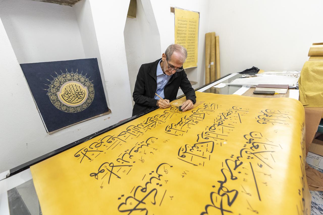 Iraqi calligrapher Ali Zaman, who moved to Istanbul with his family in 2017 after working as a jeweler in Iraq, showcases the world’s largest handwritten Quran, measuring 4 meters in length and 1.5 meters in width, in Istanbul, Türkiye, Oct. 9, 2025. (AA Photo)