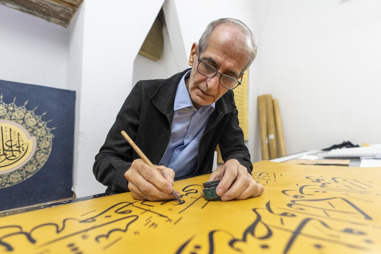 Iraqi calligrapher Ali Zaman, who moved to Istanbul with his family in 2017 after working as a jeweler in Iraq, showcases the world’s largest handwritten Quran, measuring 4 meters in length and 1.5 meters in width, in Istanbul, Türkiye, Oct. 9, 2025. (AA Photo)
