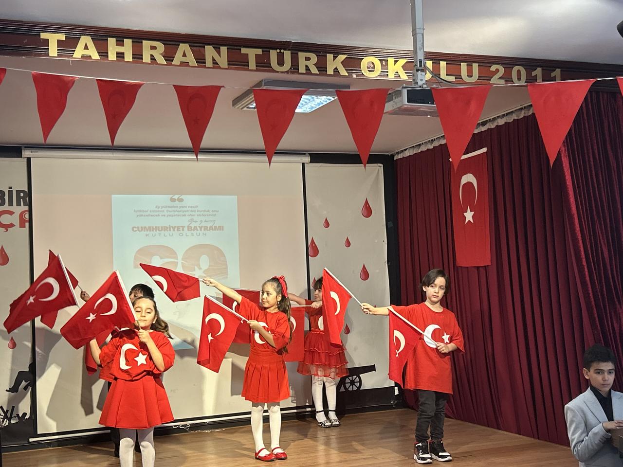 Children perform on stage waving Turkish flags during the Republic Day ceremony at the Turkish Primary School in Tehran, Iran, Oct. 28, 2025. (AA Photo)