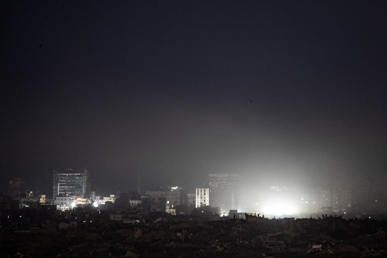 Lights from Israeli attacks illuminate damaged buildings in northern Gaza, as seen from the Sderot border area, after Israel violated the ceasefire with renewed attacks on the Gaza Strip on Oct. 29, 2025. (AA Photo)