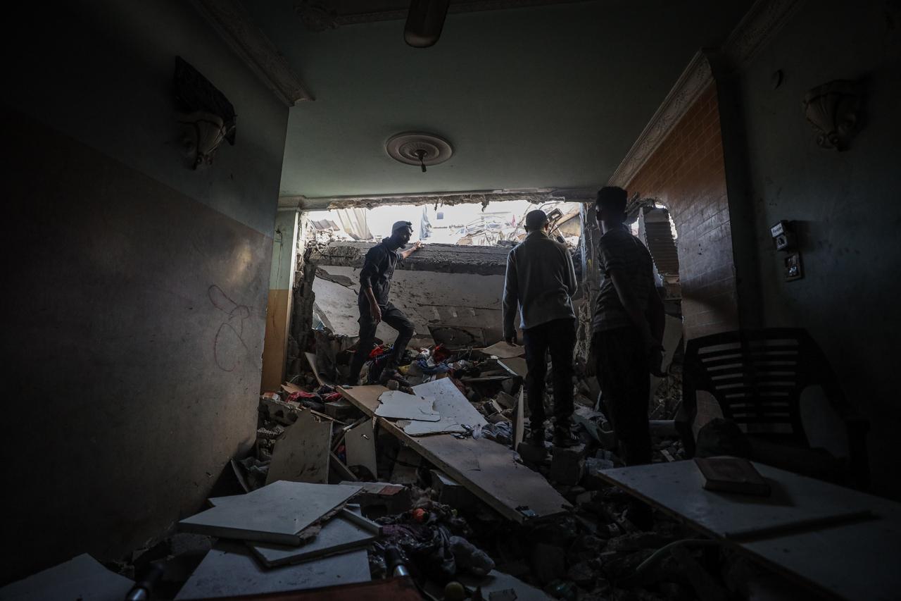 Palestinians inspect buildings damaged by Israeli forces struck the central Gaza, violating the ceasefire, on October 29, 2025. (AA Photo)