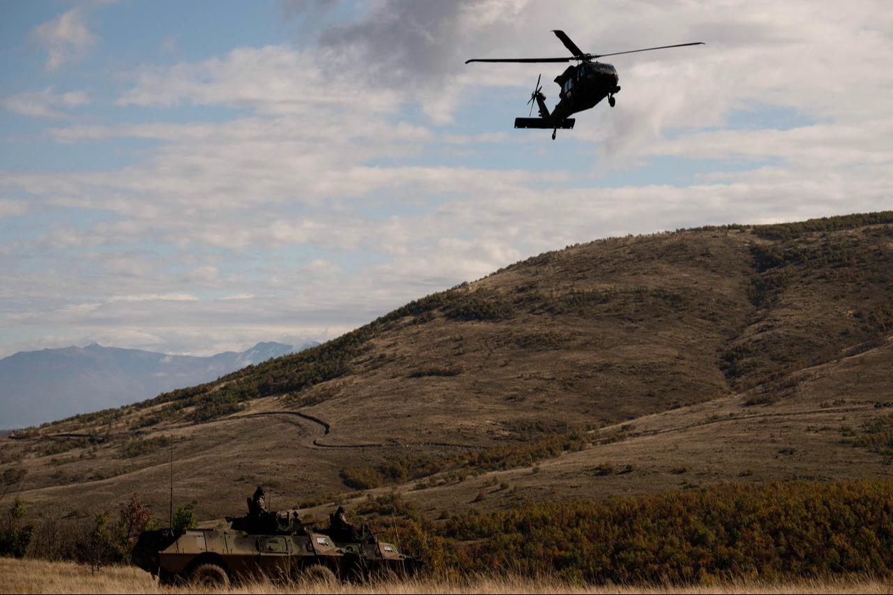 A NATO peacekeeping mission in Kosovo (KFOR) helicopter flies over armored vehicles of Kosovo Security Force (KSF) during the military exercise "Wolf Arrow", in village of Babaj Bokes, south-western Kosovo, Oct. 28, 2025. (AFP Photo)