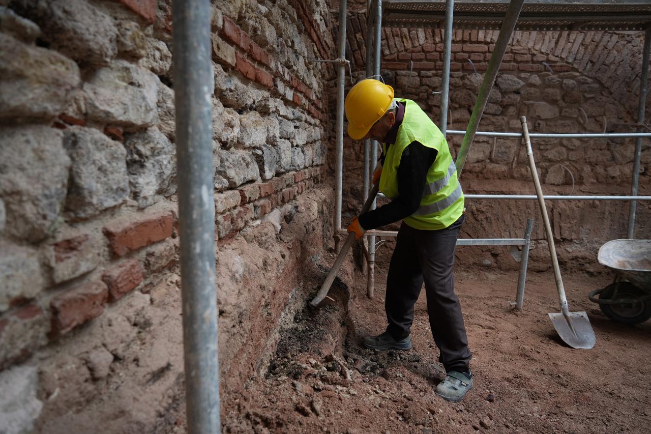 A restoration team member carefully clears soil along the original brick and stone walls of the 19th-century Unkapani Mill, one of Istanbul’s oldest industrial heritage sites, Oct. 27, 2025. (IHA Photo)