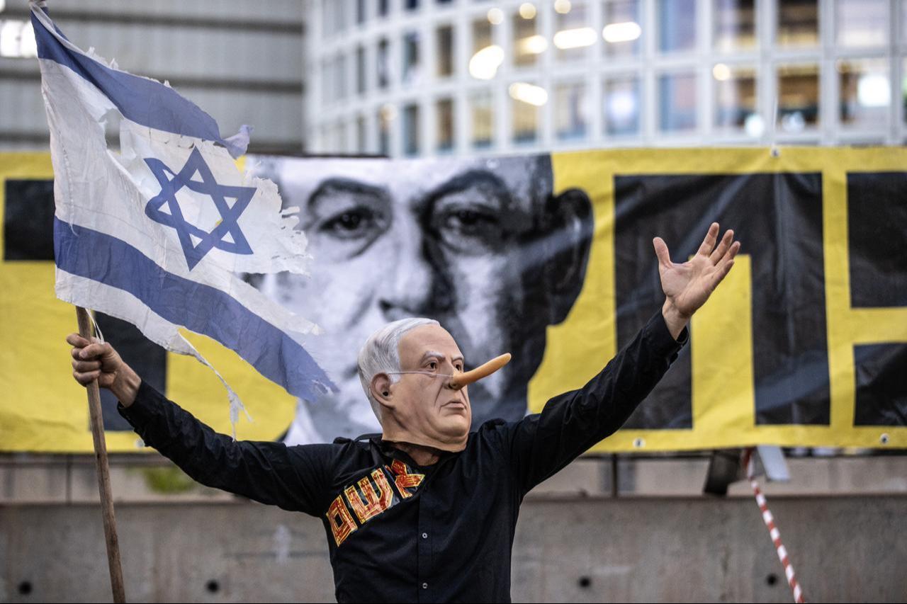 A protester wearing a Netanyahu mask holds an Israeli flag during a demonstration in Tel Aviv, Israel on May 31, 2025. (AA Photo)