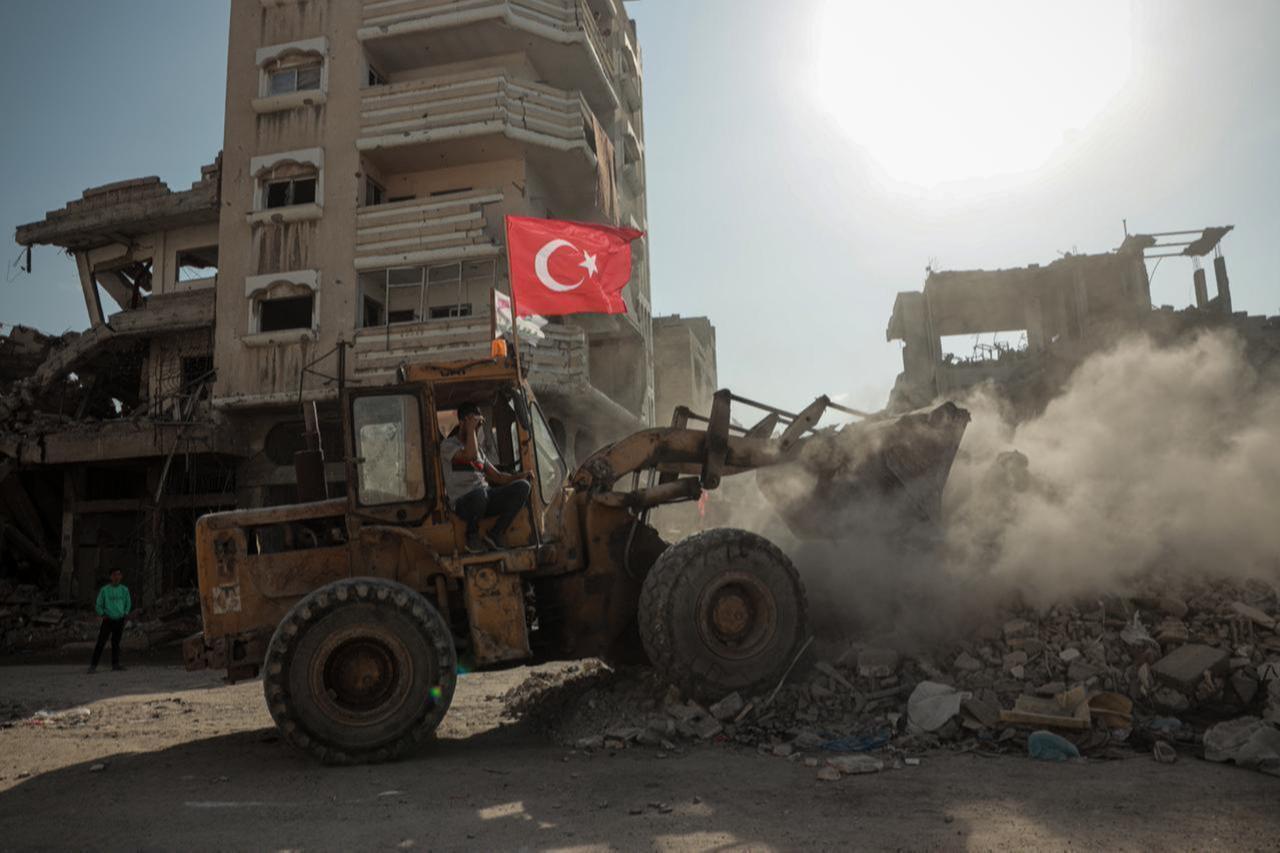 The photo shows a Turkish flag attached to an excavator, which began clearing the rubble of buildings destroyed by Israeli attacks in Gaza City, Oct. 18, 2025. (AA Photo)