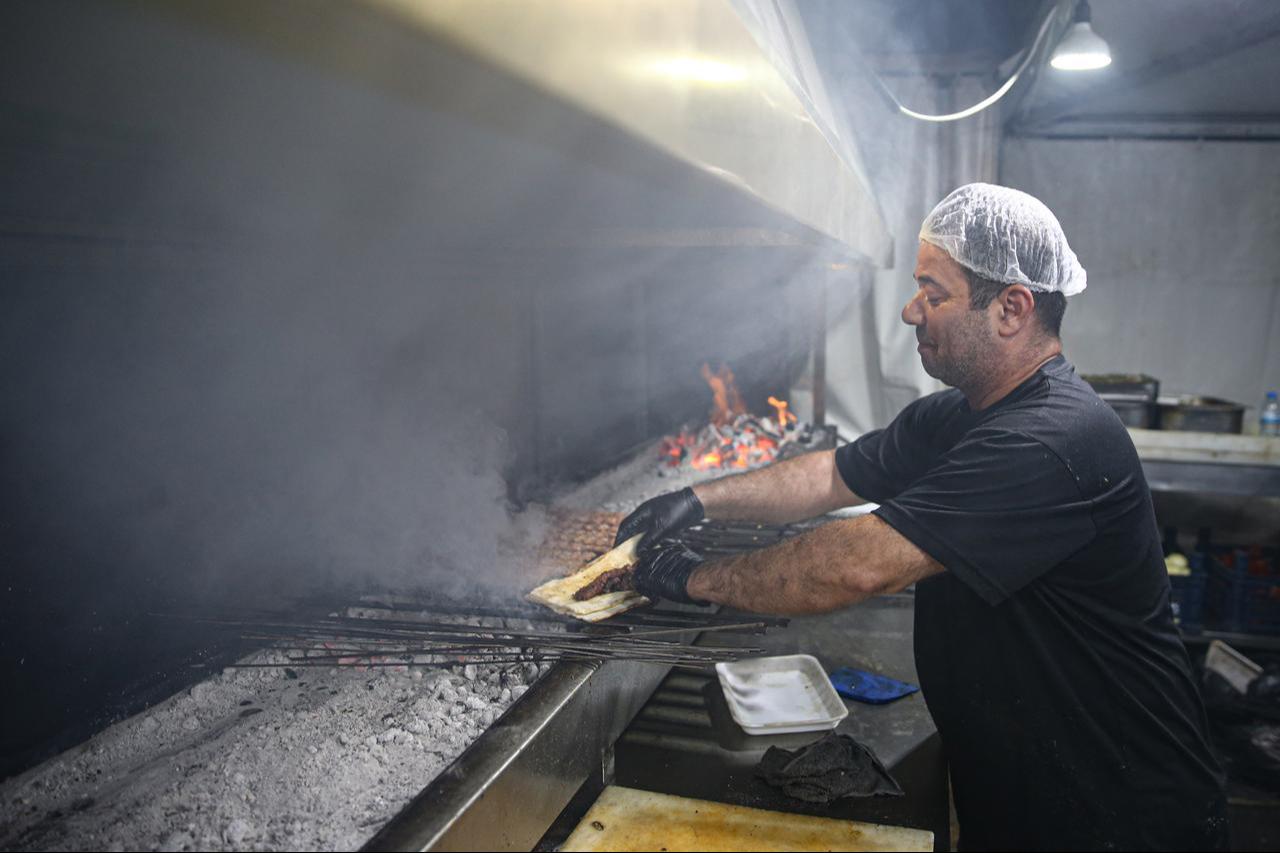 A chef grills Adana kebap over charcoal at the closing day of the International Taste of Adana Festival, Oct. 12, 2025. (AA Photo)