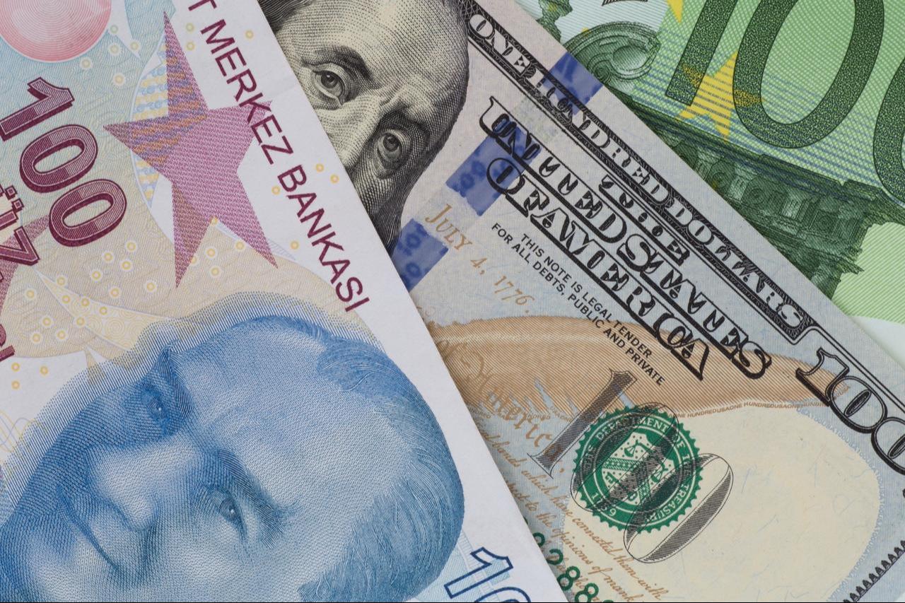 A close-up image of 100 Turkish lira, U.S. dollar, and euro banknotes. (Adobe Stock Photo)
