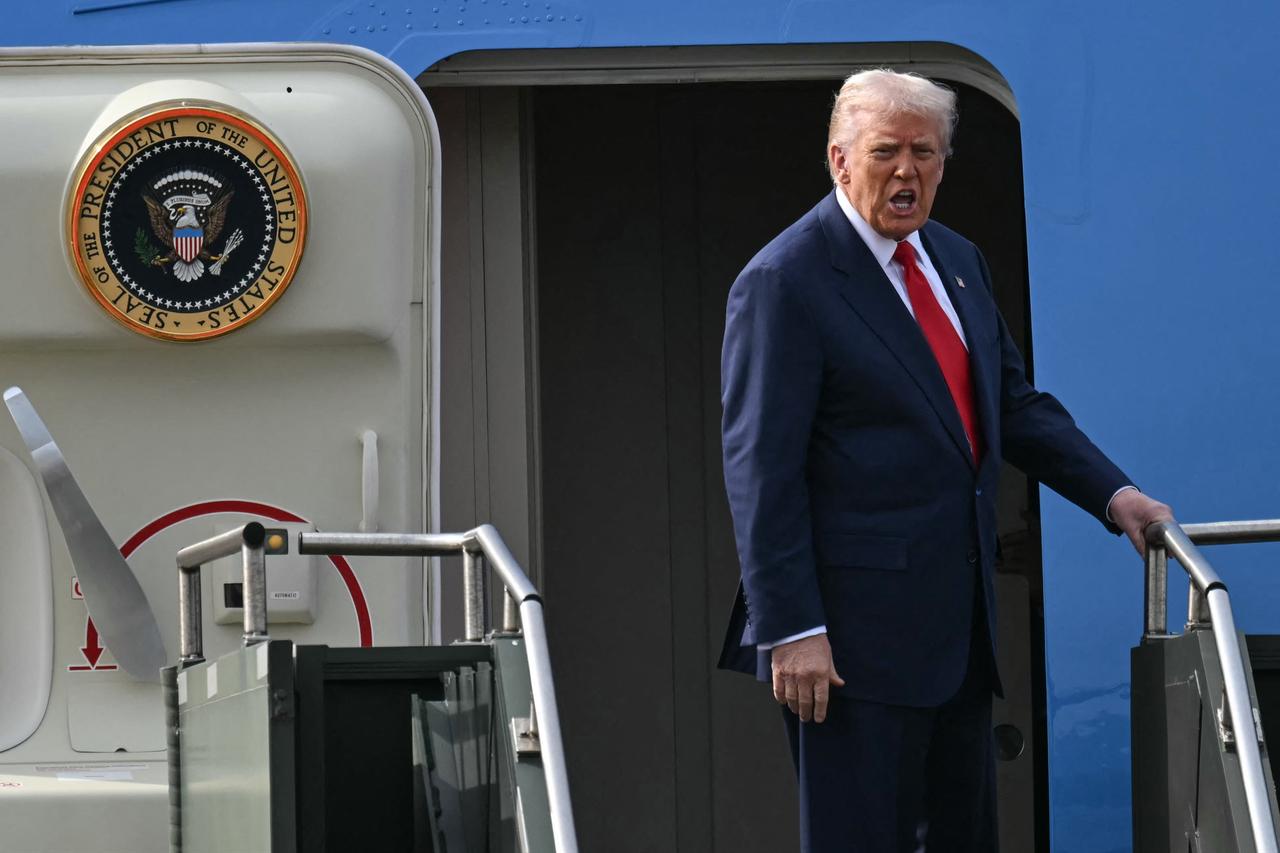 ABD Başkanı Donald Trump, 30 Ekim 2025'te Busan'daki Gimhae Uluslararası Havaalanı'nın yanında bulunan Gimhae Hava Üssü'nde Çin Devlet Başkanı Xi Jinping ile yaptığı görüşmenin ardından Air Force One'a binerken tepki gösterdi. (AFP Fotoğrafı)