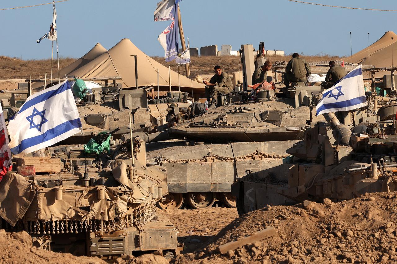 Israeli soldiers sit on top of tanks at a position in the south, near the Israel–Gaza border fence, on October 30, 2025. (AFP Photo)