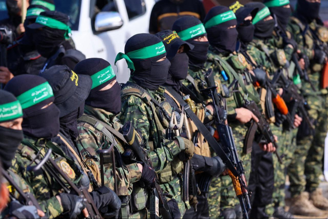 Hamas üyeleri, 25 Ocak 2025'te Gazze City'deki bir Kızıl Haç takımına dört İsrail rehinesi yayınlamadan önce bir meydanda bir bölgeyi güvence altına alıyor. (AFP fotoğrafı)