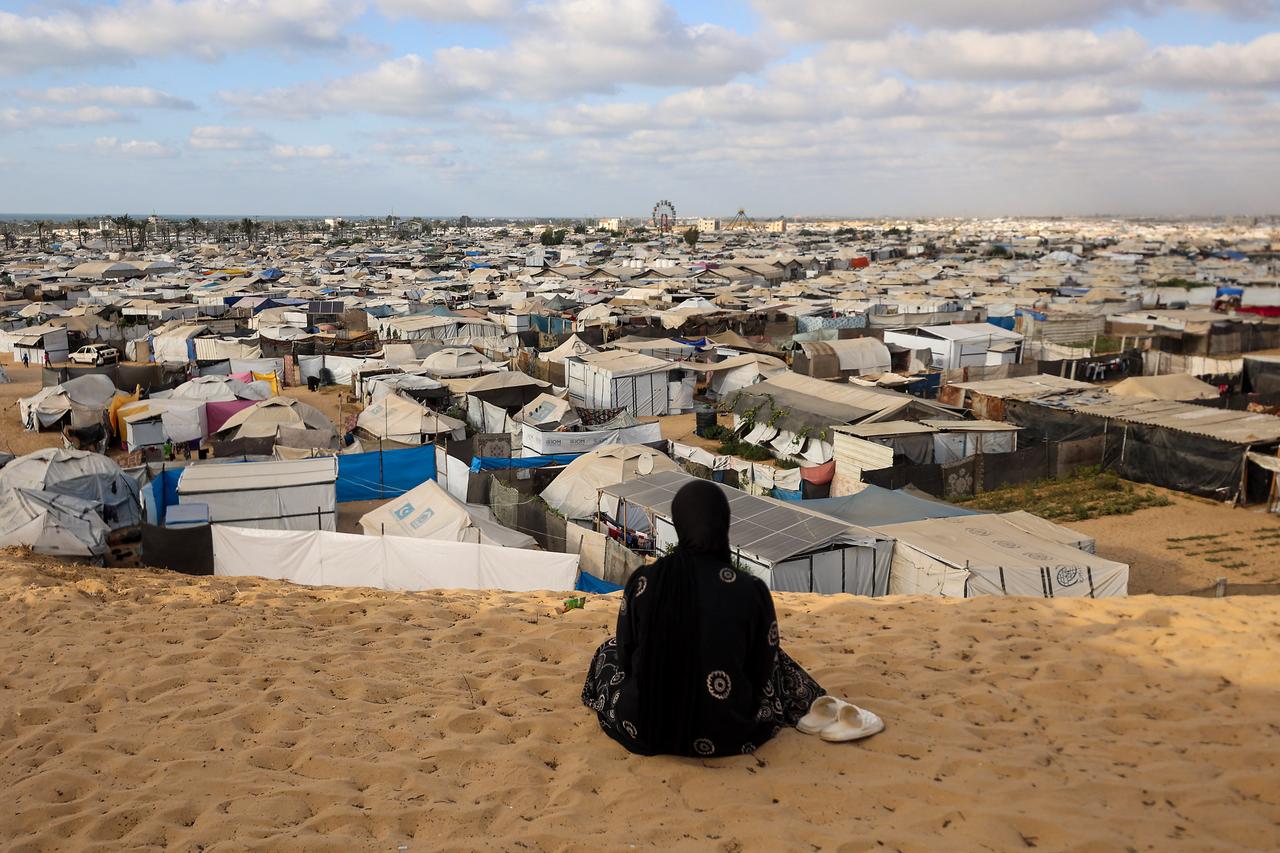 A Palestinian woman sits overlooking a camp for displaced people in Khan Yunis in the southern Gaza Strip, on September 29, 2025. (AFP Photo)
