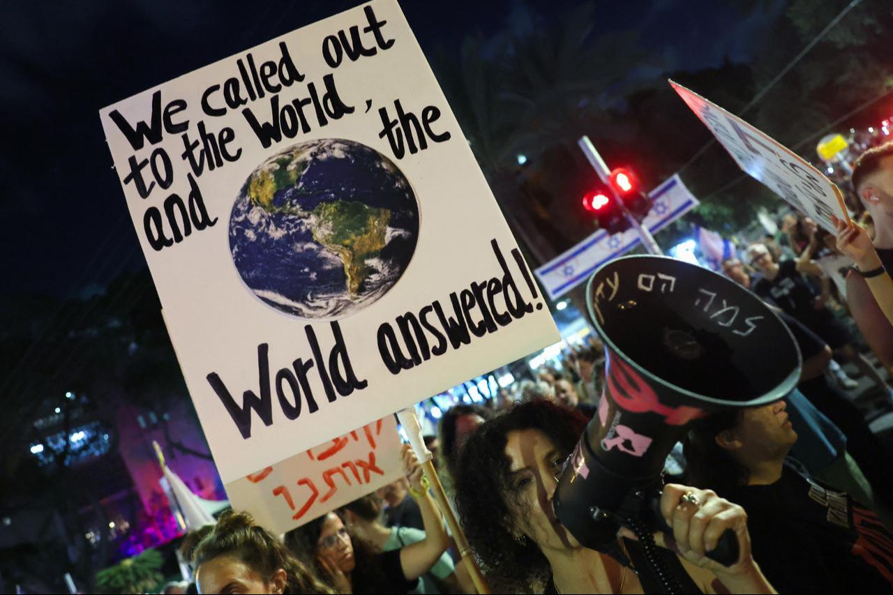 Demonstrators lift placards during an anti-government protest calling for a ceasefire in front of the Likud party building in Tel Aviv on September 30, 2025. (AFP Photo)