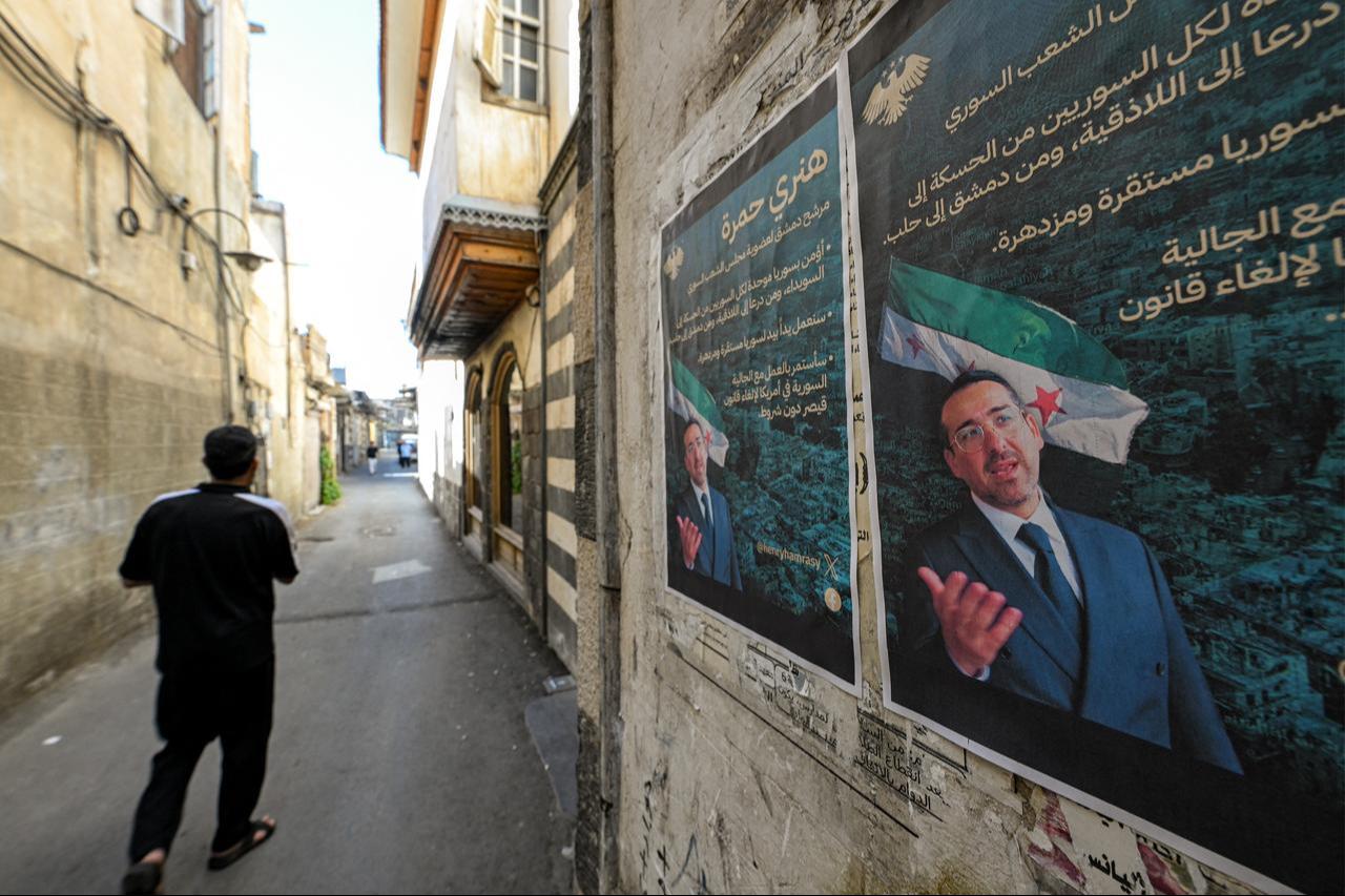 Election posters of Henry Hamra, a Syrian-American parliamentary candidate who is the son of country's last rabbi displayed on a wall along an alley in Damascus, Oct. 3, 2025. (AFP Photo)