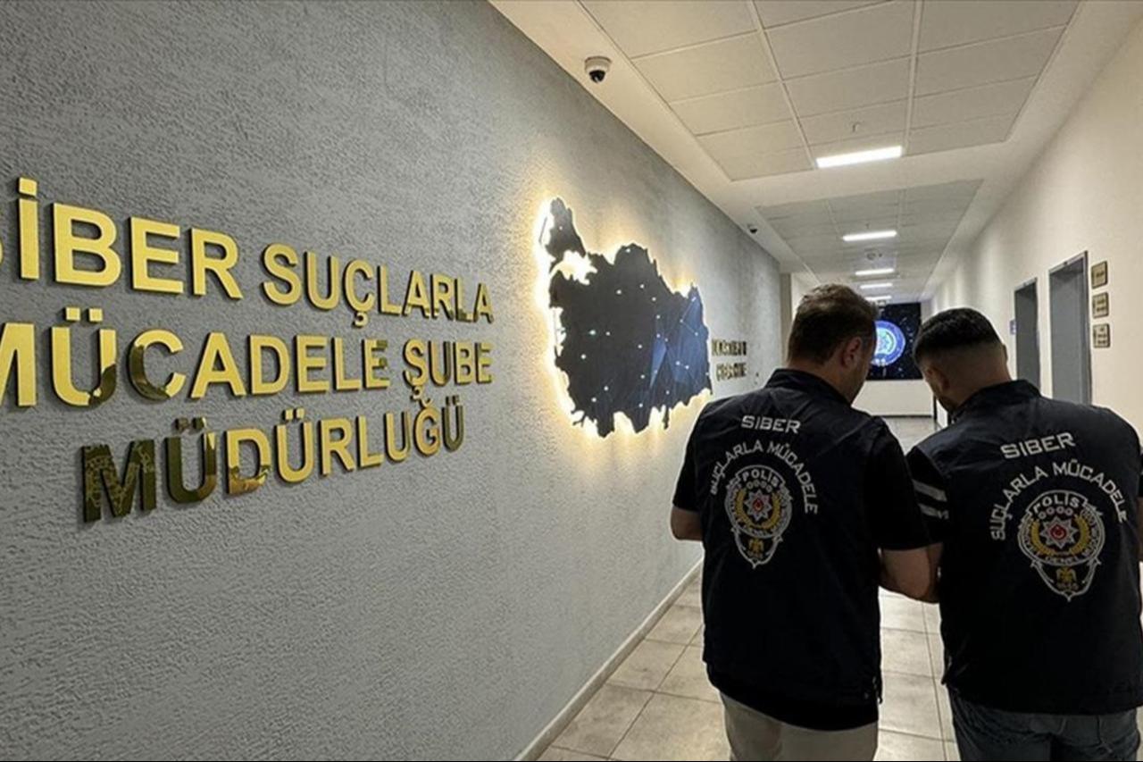 Two cybercrime police officers stand with their backs turned at Cyber Crimes Division. (AA Photo)