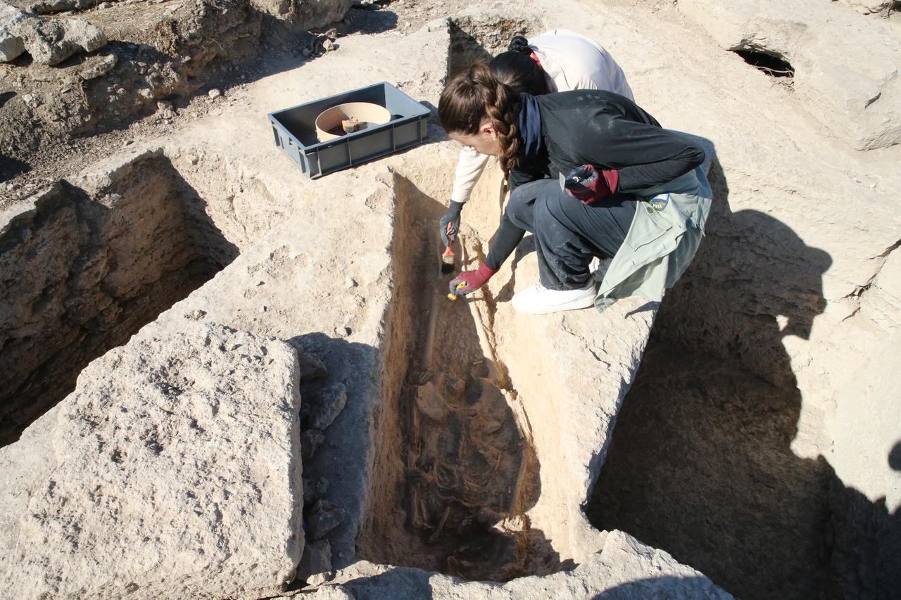 Archaeologists clean a human skeleton discovered in a rock-cut tomb during excavations at the ancient city of Colossae in Denizli, Türkiye, Oct. 6, 2025. (AA Photo)