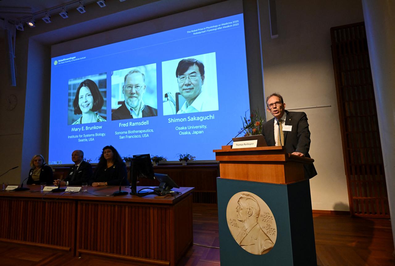 Nobel Committee Secretary General Thomas Perlmann (R) addresses journalists in front of a screen displaying the portraits of (L-R) Mary E Brunkow, Fred Ramsdell and Shimon Sakaguchi during a press conference where the winners of the 2025 Nobel Prize in Physiology or Medicine are being announced at the Karolinska Institute in Stockholm, Sweden, on Oct. 6, 2025. (AFP Photo)