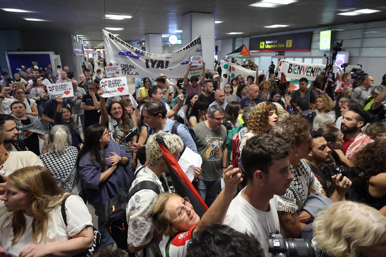 A crowd hold banners in support of the Global Sumud Flotilla, as the Spanish activists who were sailing aboard vessels from the Gaza-bound aid flotilla landed after Israel stopped the flotilla and detained hundreds of people, Madrid-Barajas Airport, Madrid, Spain on Oct. 5, 2025. (AFP Photo)
