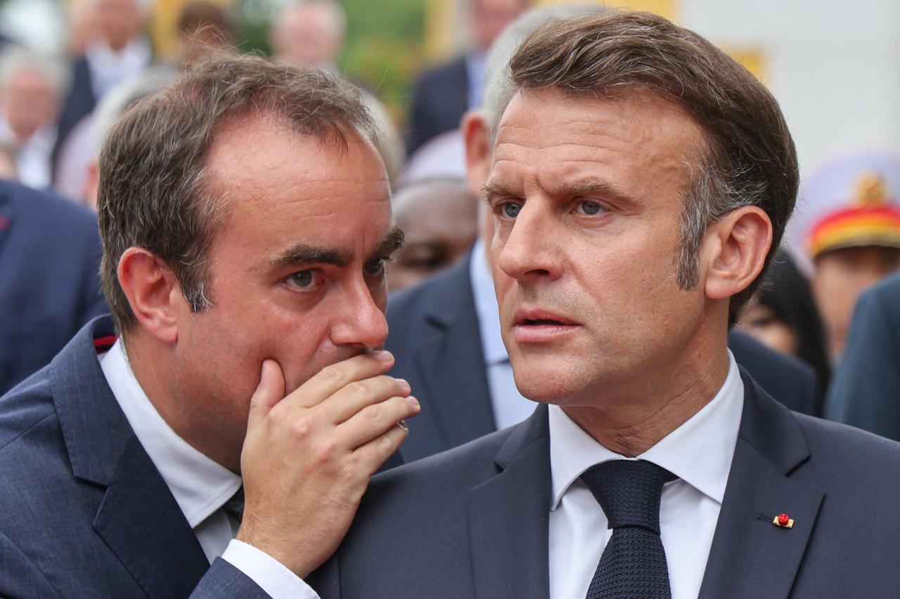 Frances President Emmanuel Macron (R) listens to then-Frances Minister of Armed Forces Sebastien Lecornu after taking part in a wreath-laying ceremony at the monument of national heroes and martyrs in Hanoi on May 26, 2025. (AFP Photo)
