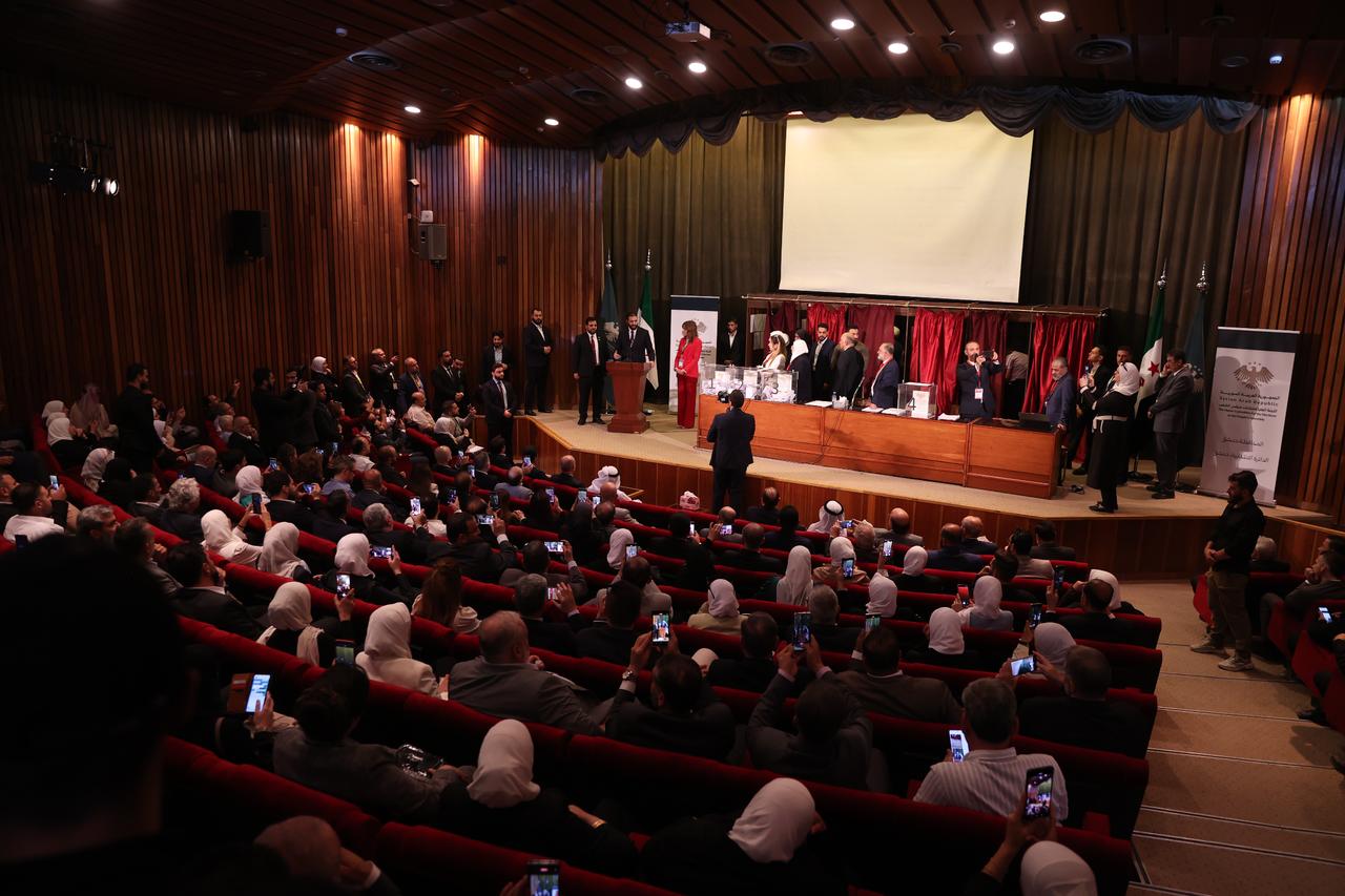 Syrian President Ahmed al-Sharaa addresses the people as he follows and receive information from election official during the Peoples Assembly election process at a polling station set up at the National Library in the capital Damascus as part of the first Peoples Assembly elections held after the fall of the Assad regime, in Damascus, Syria on October 05, 2025. (AA Photo)