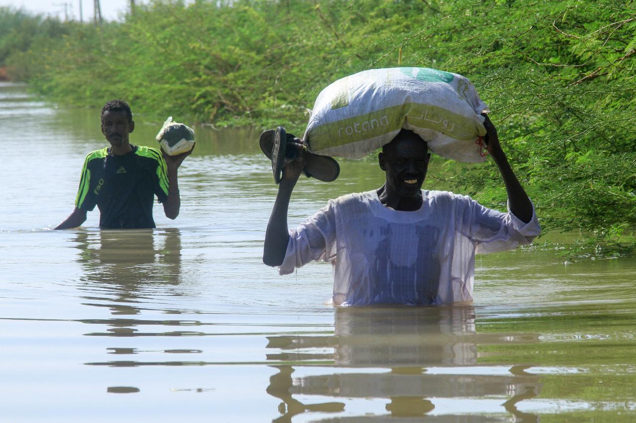 Residents wade in water as they salvage belongings due to the flooding of the Nile River in the Sudanese village of Wad Ramli, north of Khartoum, Sudan, October 1, 2025. (AFP Photo )